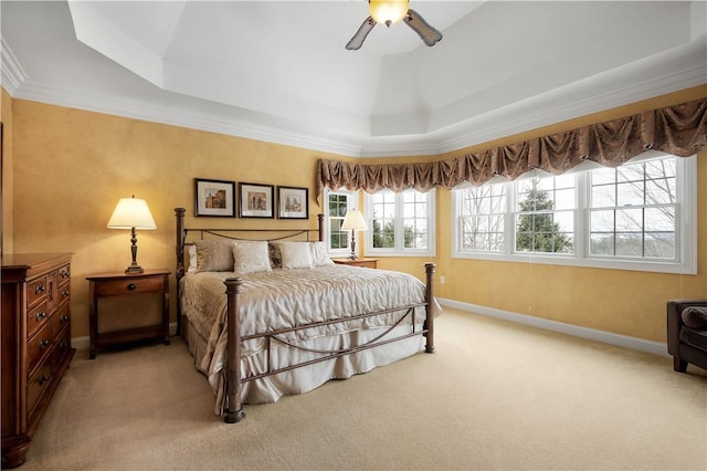 bedroom featuring baseboards, a tray ceiling, a ceiling fan, and light colored carpet