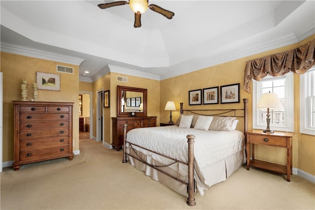 bedroom featuring light carpet, a raised ceiling, and visible vents