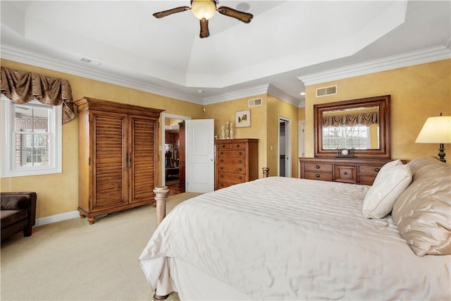 bedroom with light colored carpet, a tray ceiling, visible vents, and baseboards