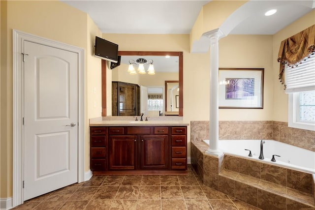 bathroom featuring a garden tub, decorative columns, tile patterned flooring, and vanity