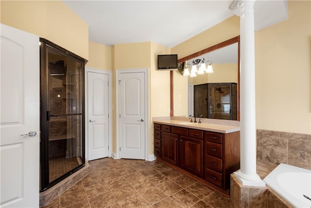 bathroom with a bath, a stall shower, vanity, and decorative columns