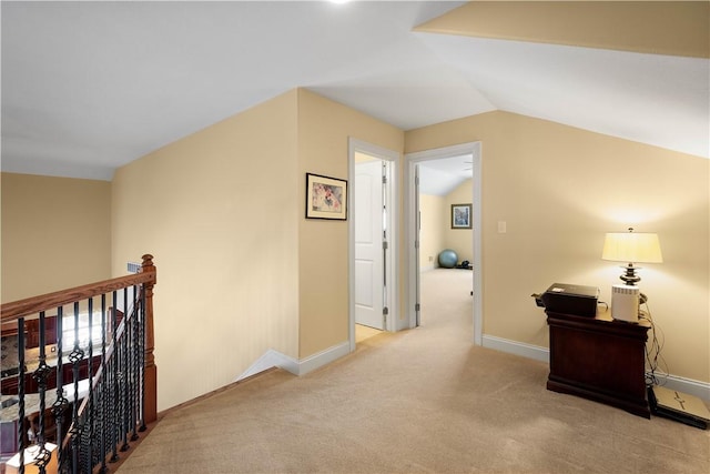 hallway featuring carpet floors, baseboards, lofted ceiling, and an upstairs landing