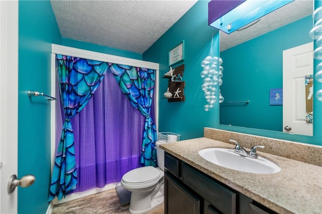 full bath with a textured ceiling, toilet, a skylight, and vanity