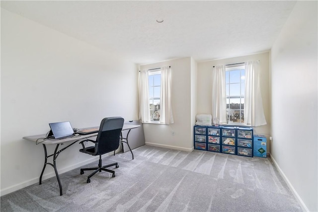 carpeted office space featuring baseboards