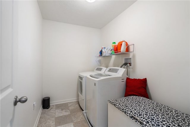 washroom featuring washer and dryer, laundry area, and baseboards