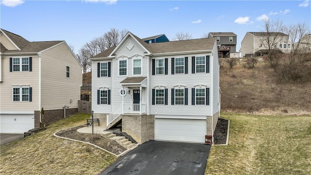 view of front of property featuring an attached garage, a front lawn, and aphalt driveway