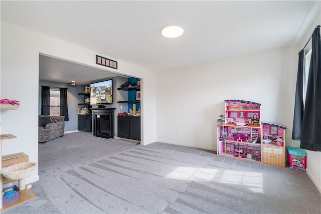 rec room with carpet, a fireplace, and baseboards