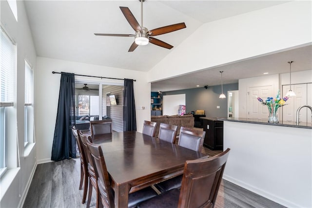 dining area with high vaulted ceiling, a ceiling fan, baseboards, and dark wood-type flooring