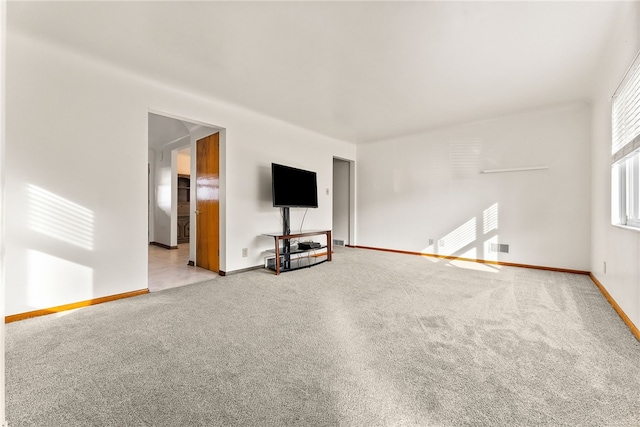 unfurnished living room with visible vents, baseboards, and carpet flooring