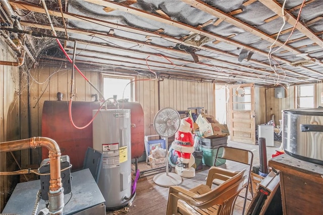 basement with water heater, wooden walls, and wood finished floors