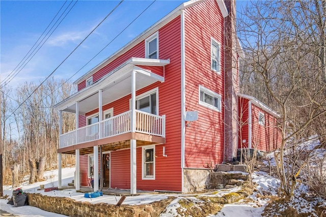 snow covered property with a balcony