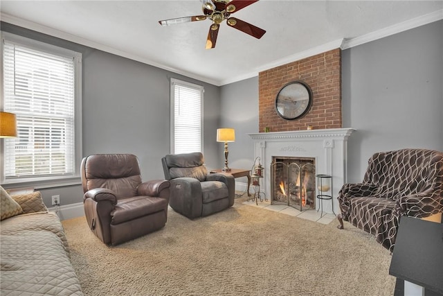 carpeted living room with ornamental molding, a large fireplace, and a ceiling fan