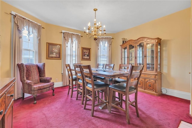 dining room with a notable chandelier, dark carpet, and baseboards