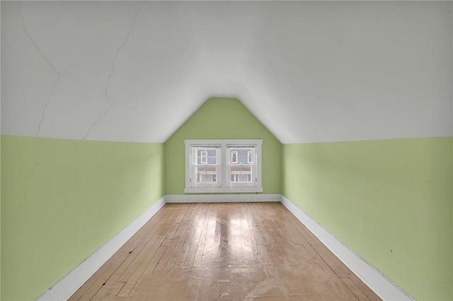 additional living space featuring lofted ceiling, wood-type flooring, and baseboards