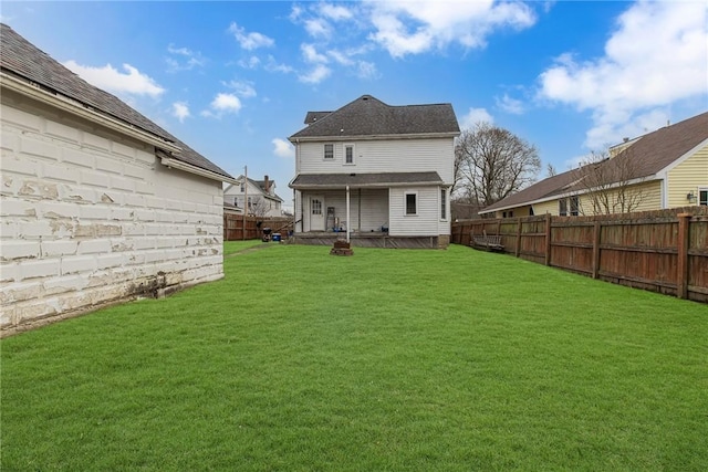 back of property featuring a lawn and a fenced backyard