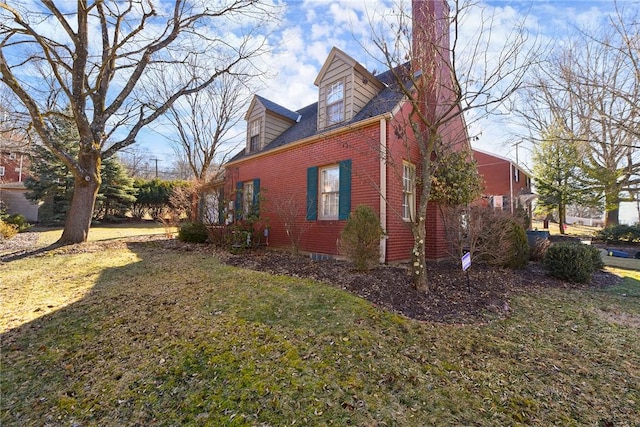 view of home's exterior featuring a lawn and brick siding