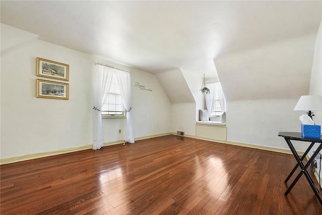 additional living space featuring lofted ceiling, baseboards, visible vents, and hardwood / wood-style floors