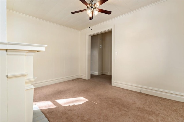 empty room with baseboards, ornamental molding, ceiling fan, and carpet flooring