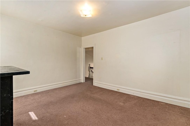 unfurnished room with carpet flooring and baseboards