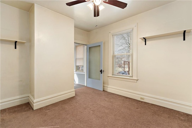 interior space with a ceiling fan, carpet flooring, and baseboards