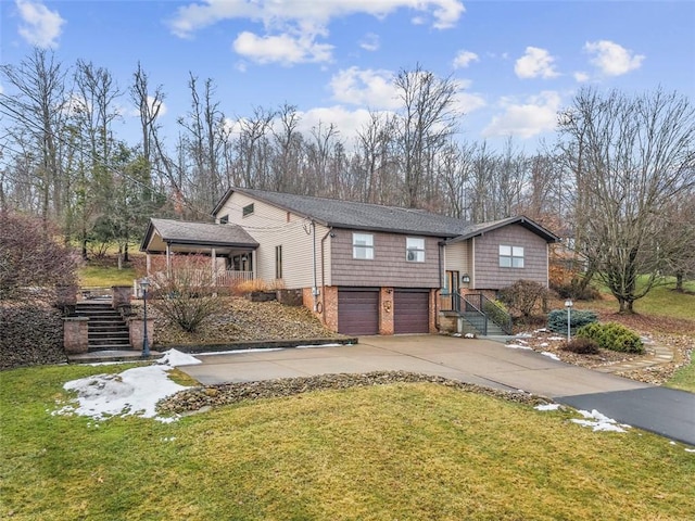 view of front of property with a front lawn, concrete driveway, an attached garage, and stairs