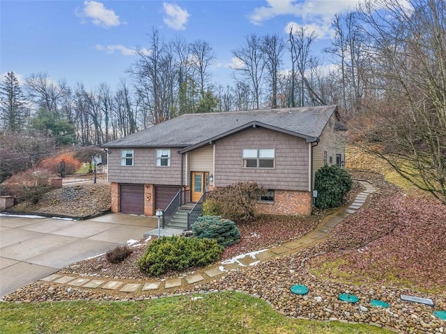 bi-level home with driveway, brick siding, and an attached garage