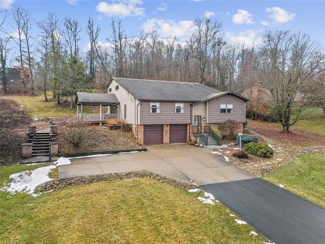 view of front of house with driveway, an attached garage, stairway, and a front yard