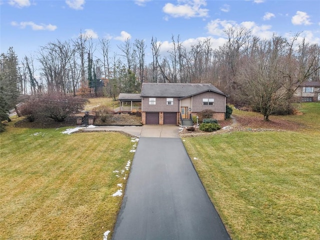 view of front facade with a garage, driveway, and a front lawn