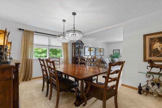 dining room featuring baseboards and light colored carpet