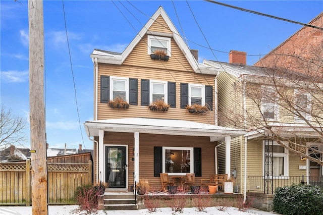 view of front of home with fence and a porch