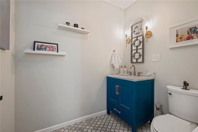 bathroom with toilet, baseboards, and vanity