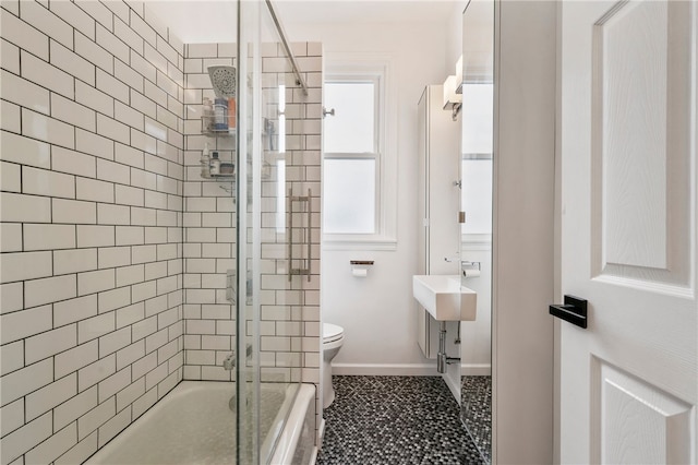 bathroom featuring toilet, tile patterned floors, baseboards, and shower / bathtub combination