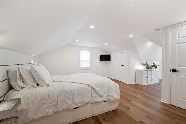 bedroom featuring vaulted ceiling, baseboards, wood finished floors, and recessed lighting