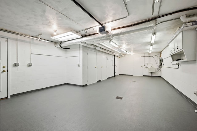 garage with concrete block wall and a garage door opener