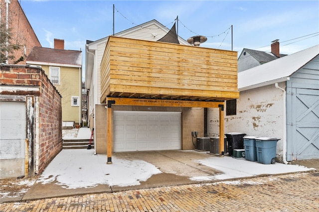 exterior space with a garage and cooling unit