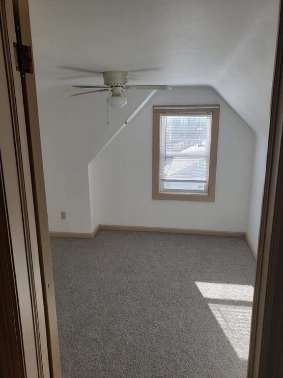 bonus room featuring lofted ceiling, a ceiling fan, baseboards, and carpet flooring