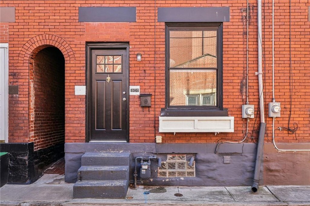 entrance to property featuring brick siding
