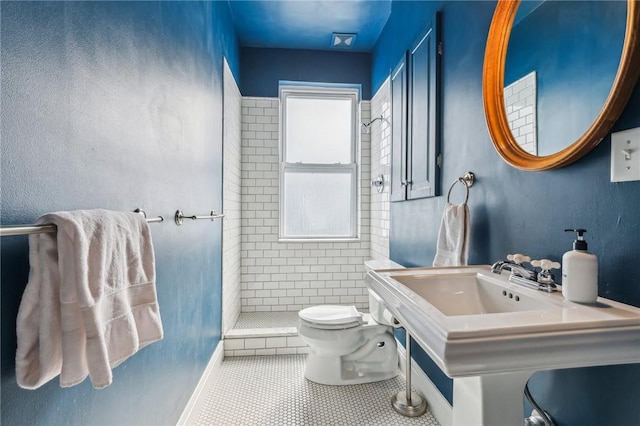 full bath featuring toilet, a stall shower, and tile patterned floors