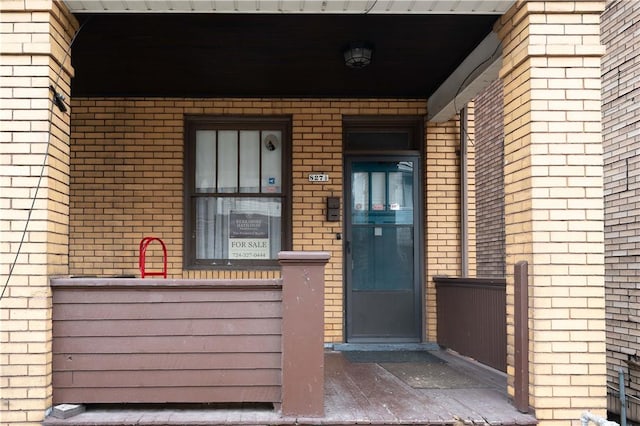 doorway to property featuring brick siding