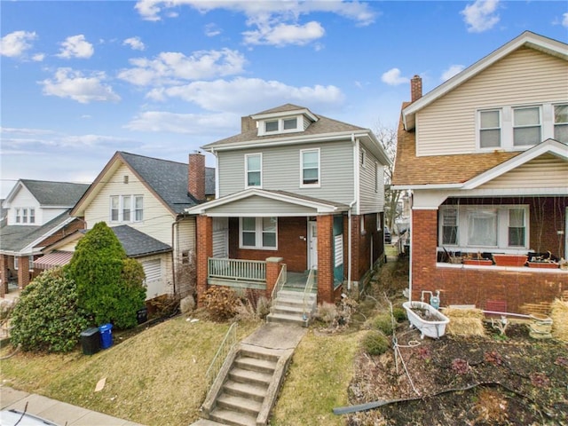 american foursquare style home with covered porch, brick siding, stairway, and roof with shingles