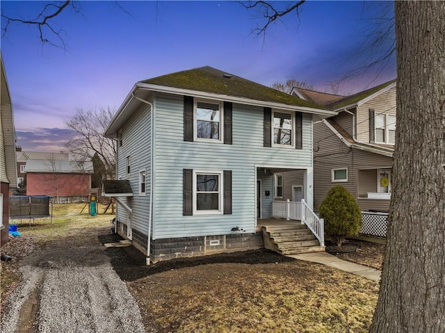 view of front of home with a trampoline and covered porch