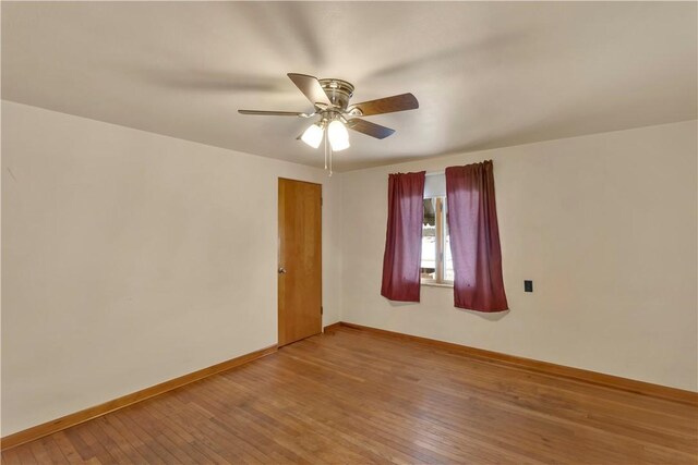 empty room featuring ceiling fan, wood-type flooring, and baseboards