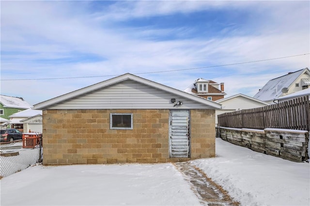 snow covered property with an outbuilding and a fenced backyard