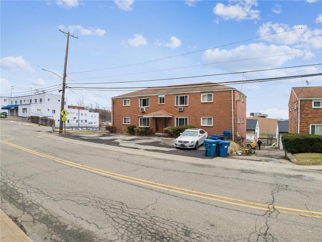 view of front of house with uncovered parking and brick siding