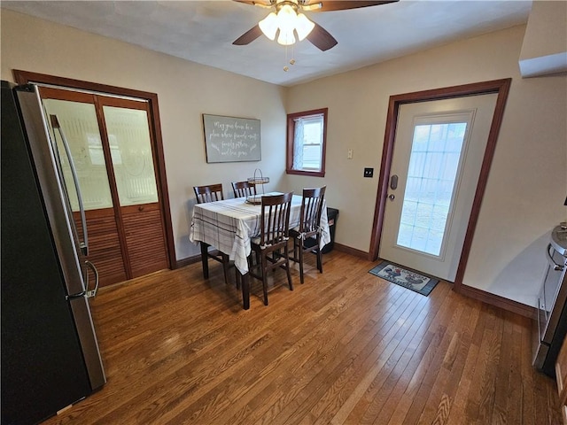 dining room featuring wood-type flooring, baseboards, and ceiling fan