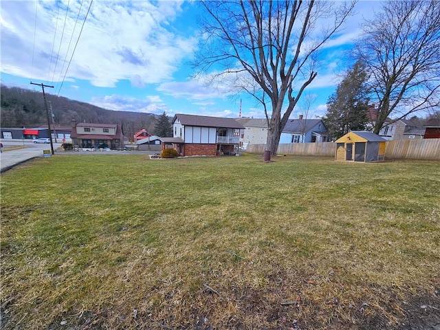 view of yard with fence and an outdoor structure