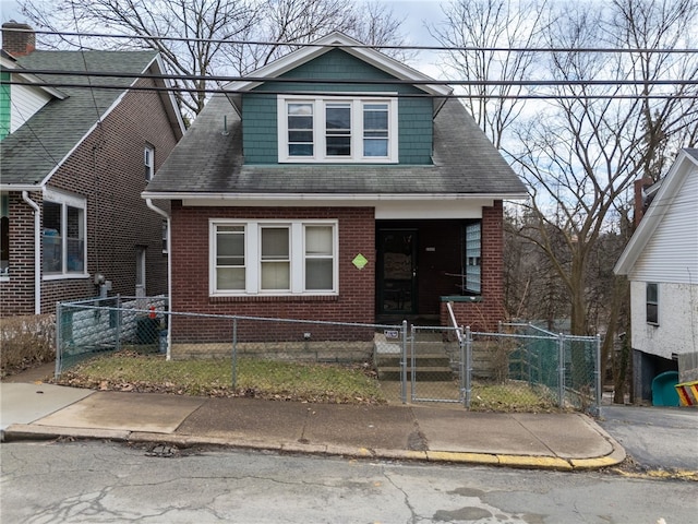 bungalow featuring brick siding, a fenced front yard, a shingled roof, and a gate