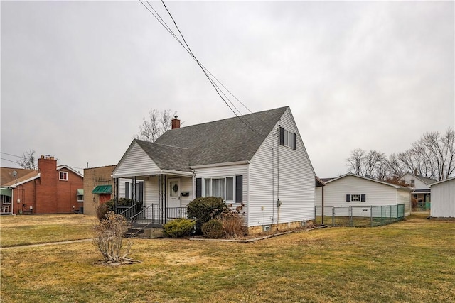 view of front facade with a shingled roof, fence, a chimney, and a front lawn