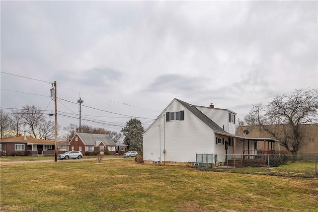 view of property exterior featuring a chimney, fence, and a lawn