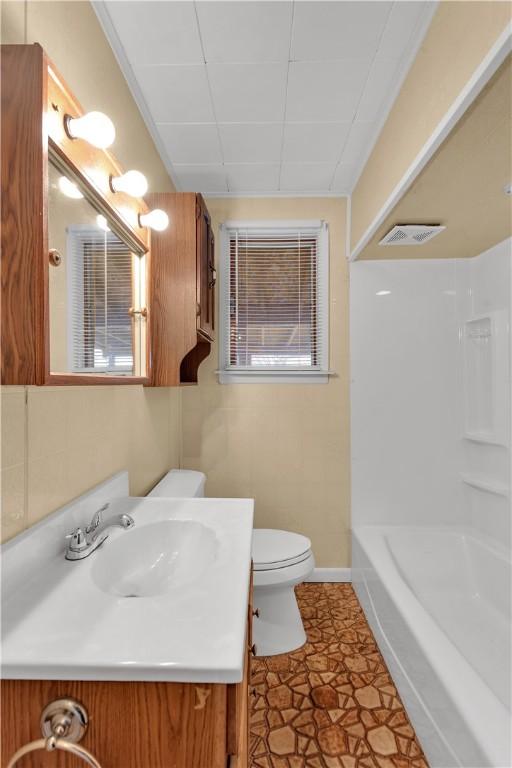 bathroom with baseboards, visible vents, vanity, and toilet